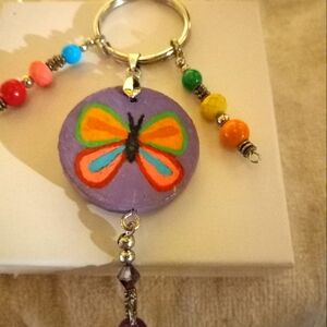 Handpainted  butterfly keychain on a wood disc with hanging  butterfly charms.